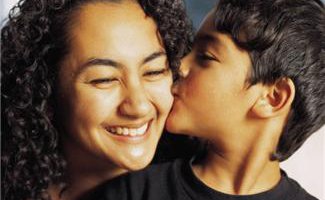 young boy kissing woman